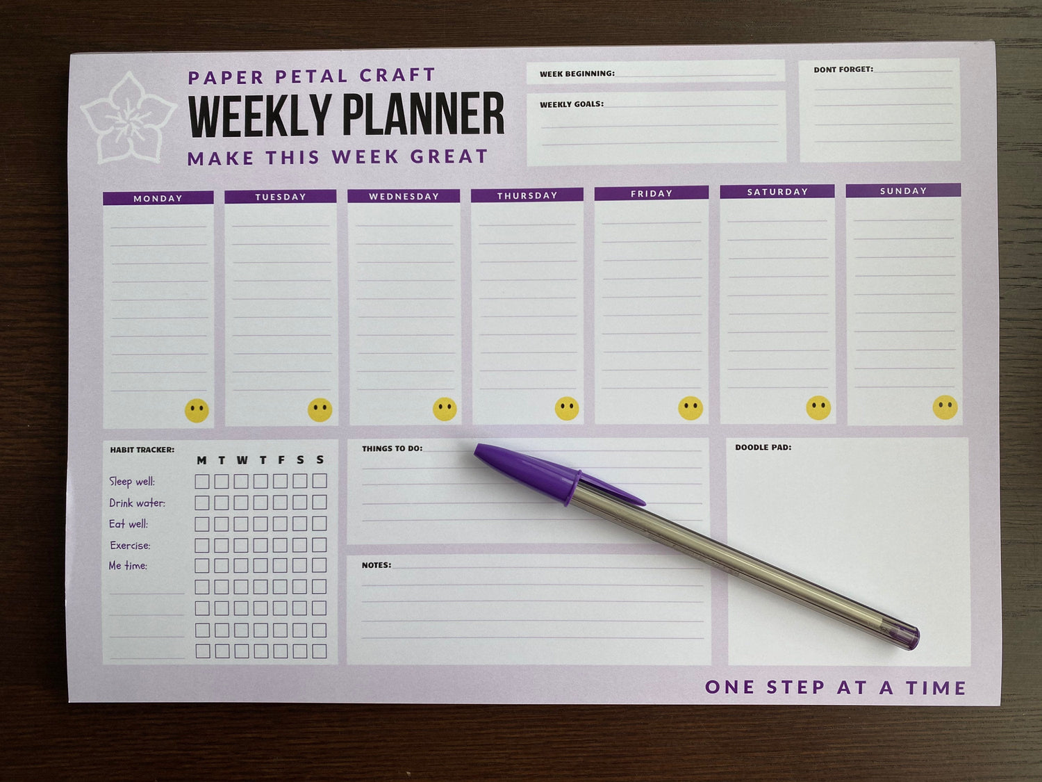 7 day weekly planner & purple pen. Quote:" make this week great - one step at a time"  Includes habit tracker and doodle pad